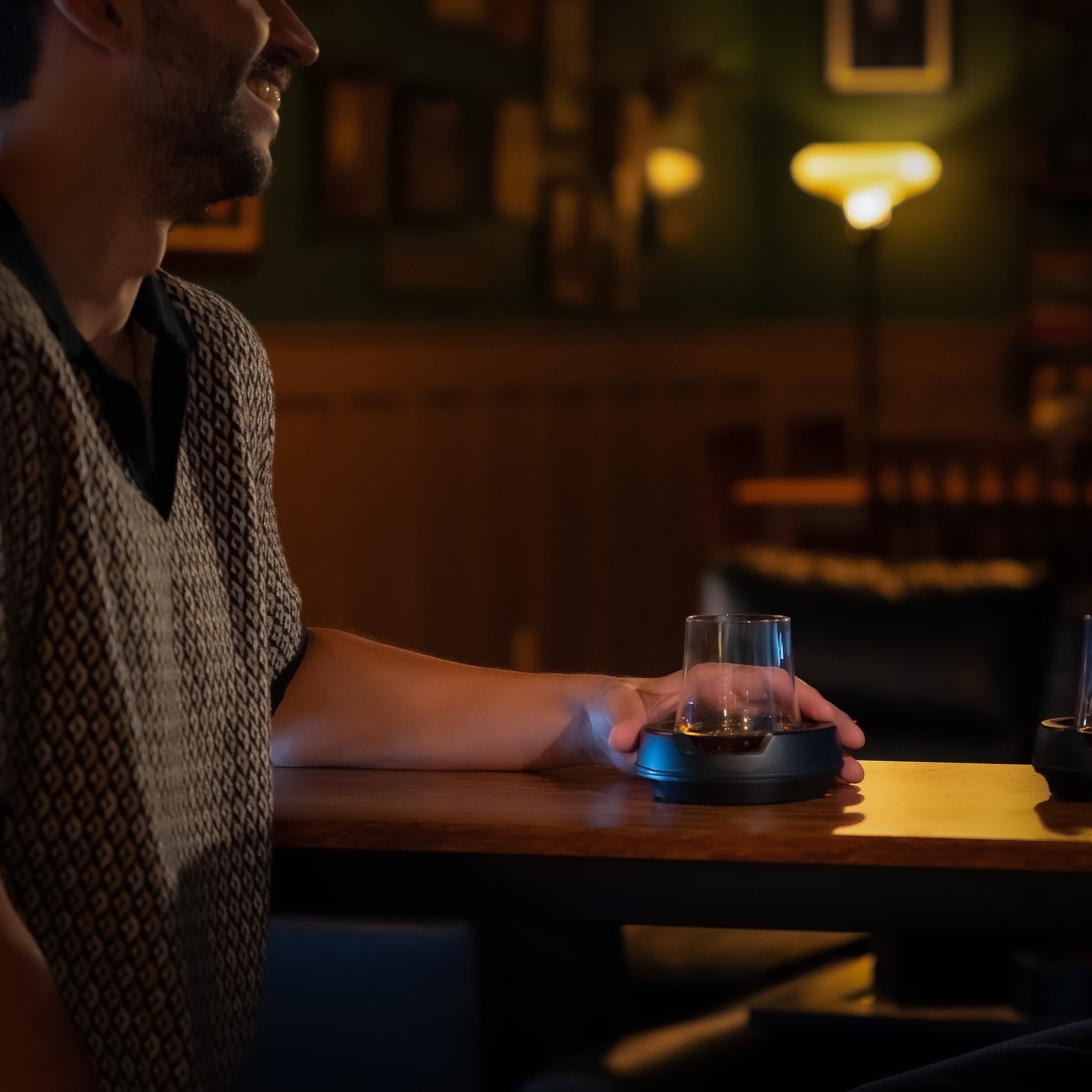 man holding whiskey glass with whiskey chiller