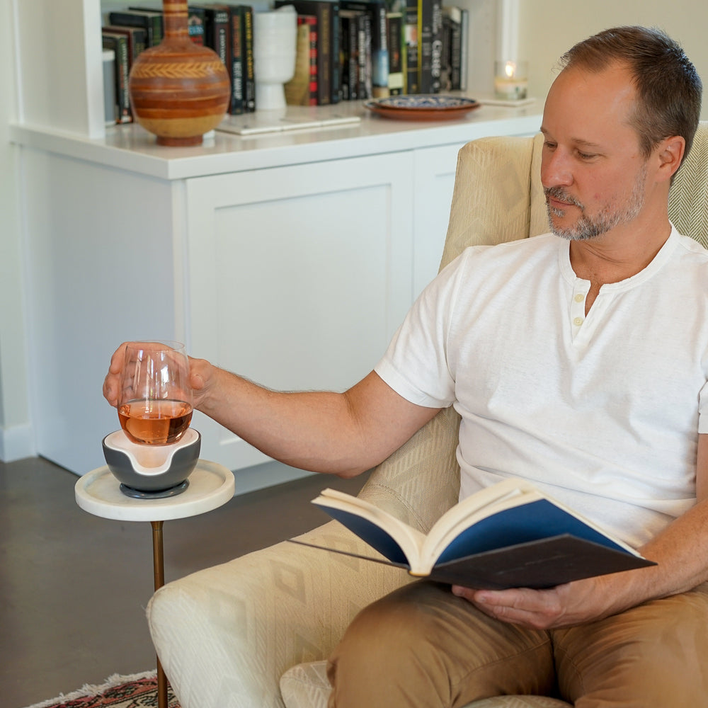 man reading book and drinking wine from a wine chiller. VoChill personal wine glass chiller.