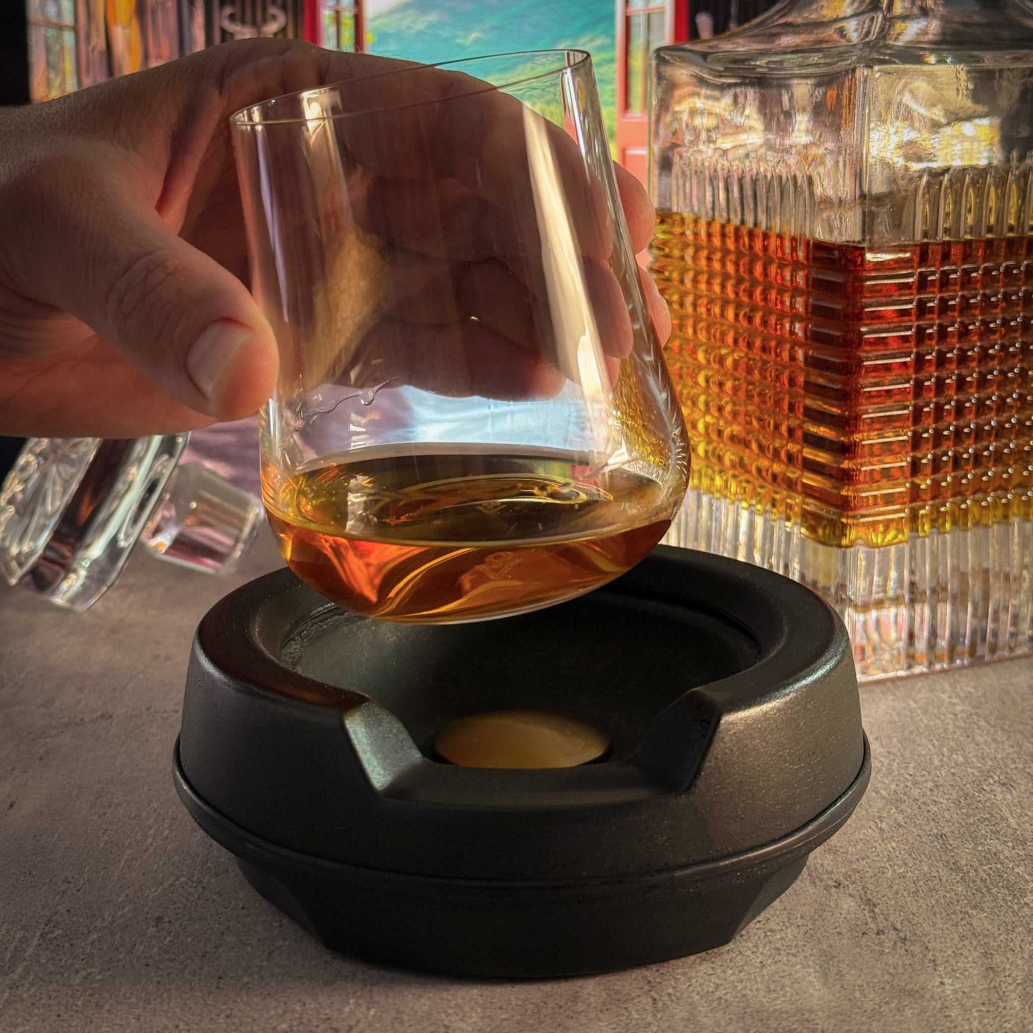 A hand lifting a the vochill spirits glass from the spirits chiller. The glass contains whiskey.