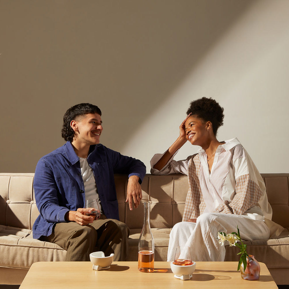 Man and woman sitting on sofa having a good time while enjoying wine with VoChill wine chillers