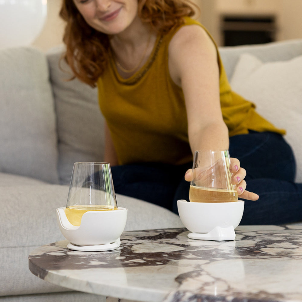 
                      
                        Woman placing a stemless wine glass with white wine into a VoChill stemless wine chiller.
                      
                    