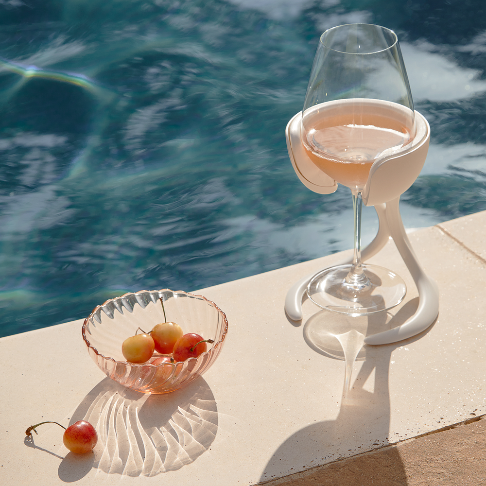 
                      
                        A VoChill stemmed wine glass chiller holding a chilled glass of rosé wine by a sunny poolside
                      
                    
